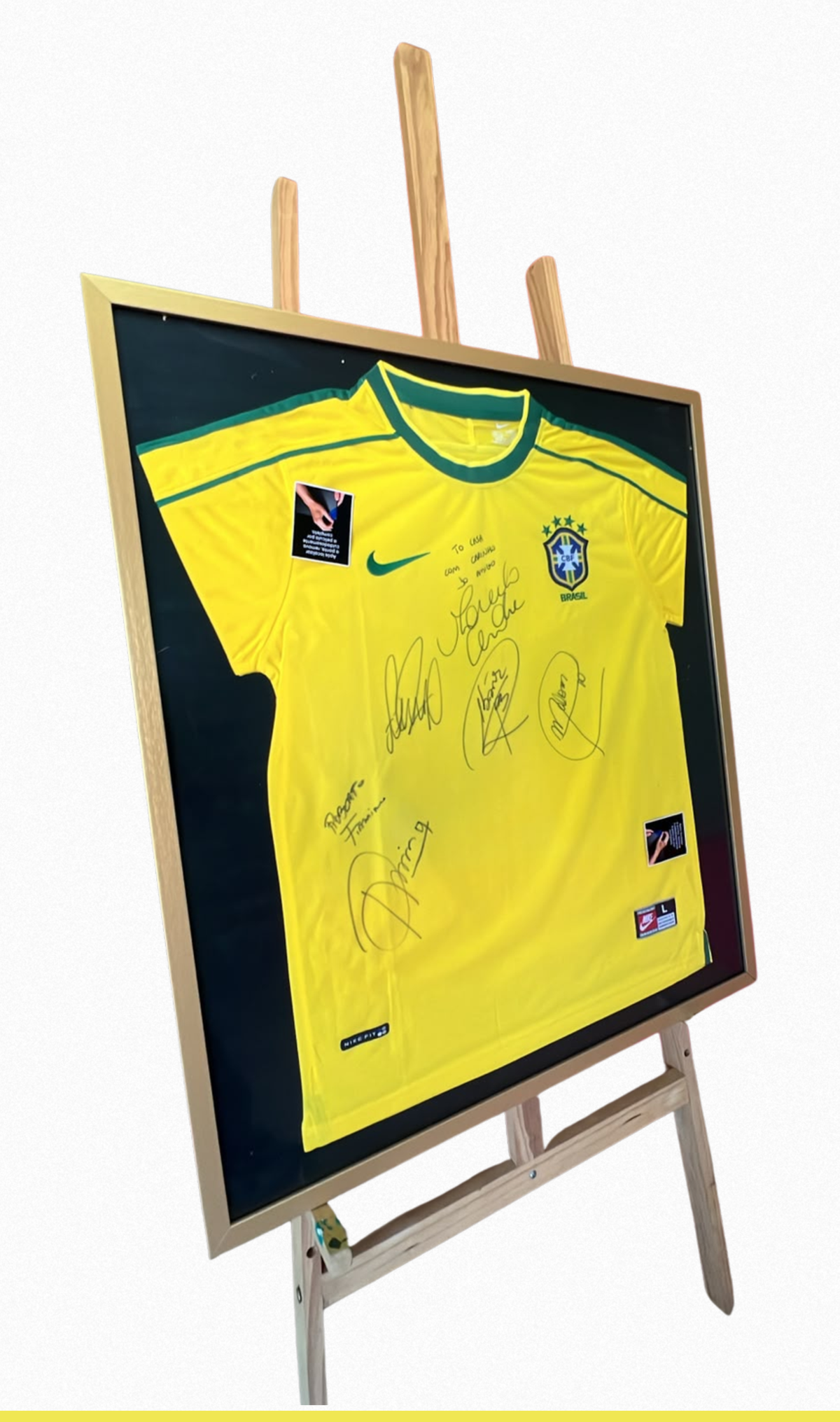 A camisa autografada em sua moldura, exposta sobre um cavalete.